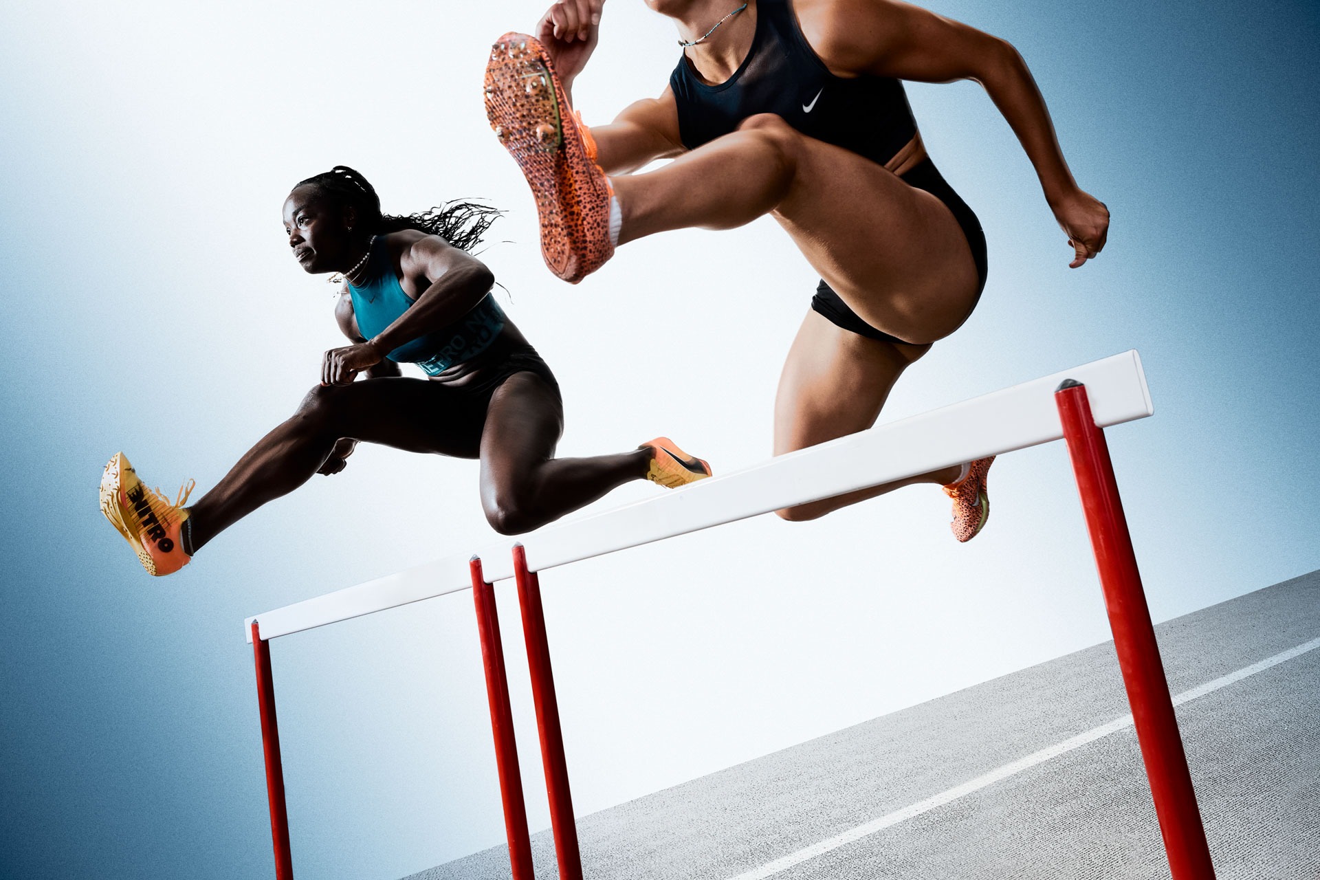 Athlete clearing a hurdle mid-stride during a hurdles race